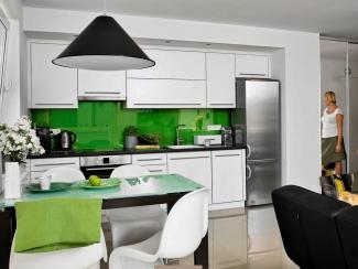 Białe meble kuchenne i zielony kolor ścian